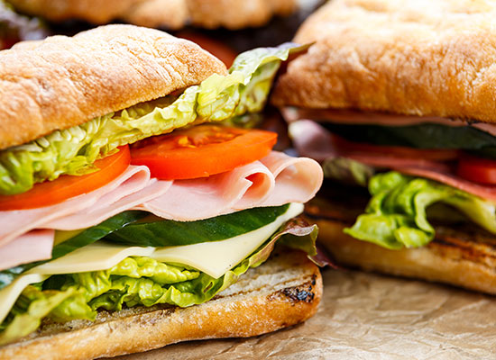 Fresh sub sandwiches with tomatoes, lettuce, and ham
